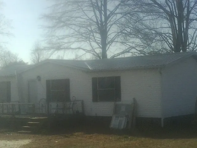 New metal roof on a white painted brick home on a foggy morning in Delaware